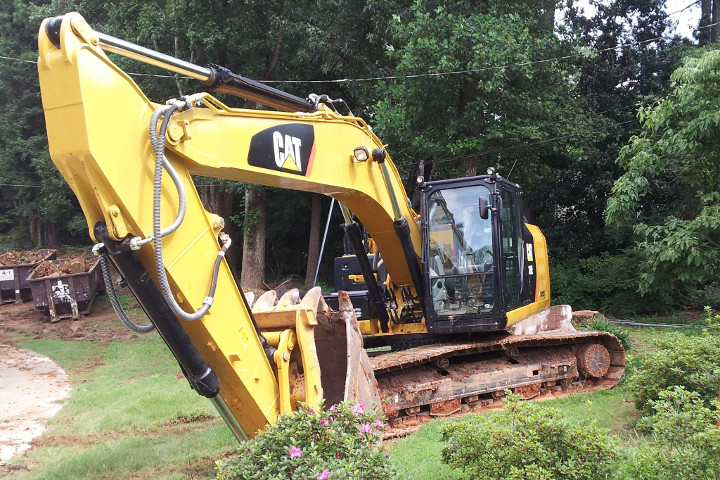 Excavator with two loaded rolloff containers